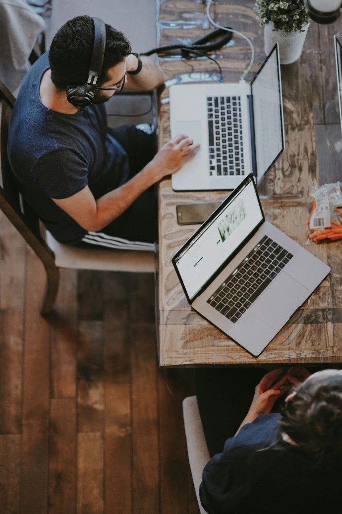 man sitting on chair and looking at laptop computer